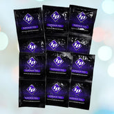 A set of nine black and purple foil packets of ID Superior Feel Condoms by ID Condoms, arranged in a grid pattern against a soft, out-of-focus background with light blue and white circles for enhanced sexual satisfaction.